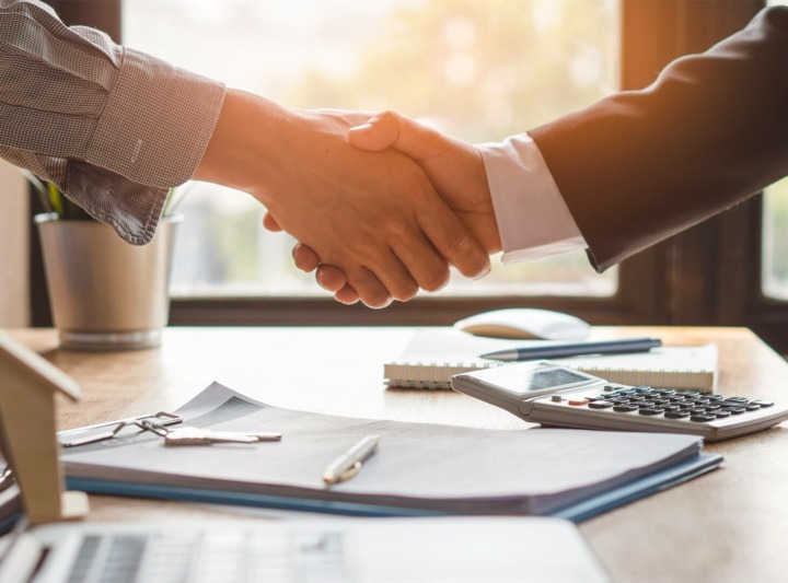 A client and an interior designer shake hands after agreeing on a project